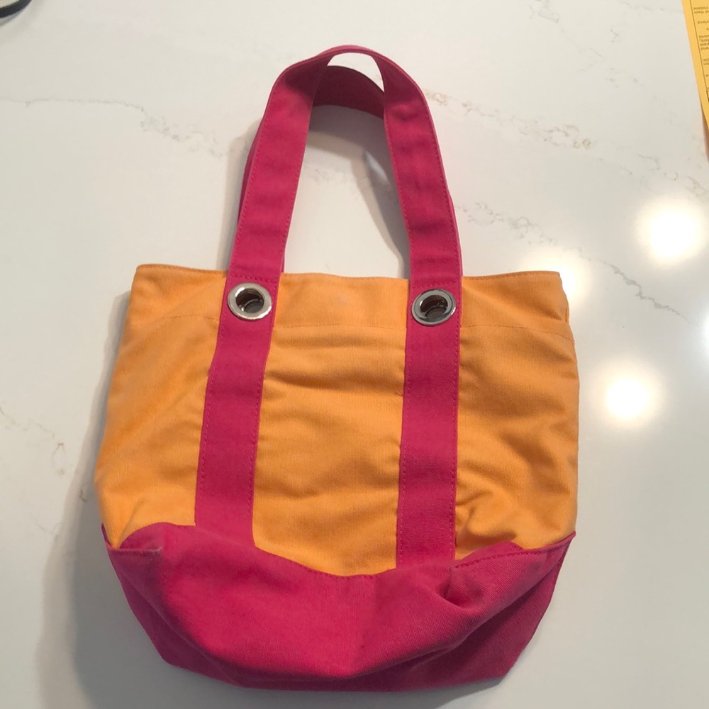 An orange and pink purse with multiple pockets.